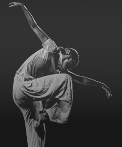 Black and white image of a dance mid-movement during a modern dance performance