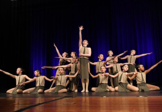 Group of dancers in matching outfits performing a stage routine together